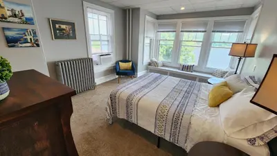 a bedroom with a bed and a desk and windows at Waterfront Getaway in Historic Bristol in Bristol