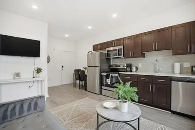 a kitchen with brown cabinets and a table in a room at 1BR1BA apartment in the Fairmount Square building in Philadelphia