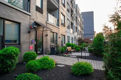 a courtyard in front of a building with bushes at 1BR1BA apartment in the Fairmount Square building in Philadelphia