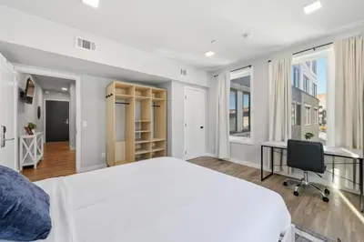 a bedroom with a bed and a desk and windows at Cozy 1BR Apartment in Philly Prime Location in Philadelphia