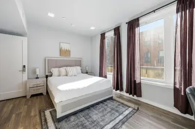 a white bedroom with a bed and a window at Sleek 1BR apartment in Philly in Philadelphia