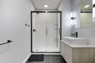 a white bathroom with a shower and a sink at Sleek 1BR apartment in Philly in Philadelphia
