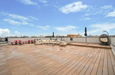 a rooftop deck with couches and tables on a building at Sleek 1BR apartment in Philly in Philadelphia
