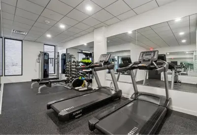 a gym with two tread machines and a mirror at Sleek 1BR apartment in Philly in Philadelphia