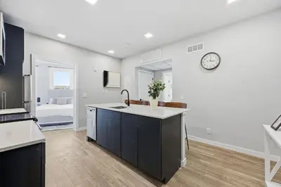 a kitchen with a sink and a clock on the wall at Contemporary 2BR Apartment Near Everything in Philadelphia