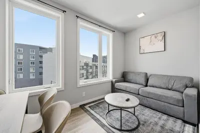 a living room with a couch and two windows at Contemporary 2BR Apartment Near Everything in Philadelphia