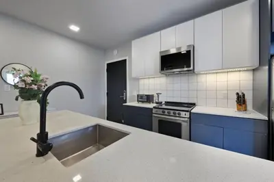 a kitchen with a stainless steel sink and blue cabinets at Contemporary 2BR Apartment Near Everything in Philadelphia
