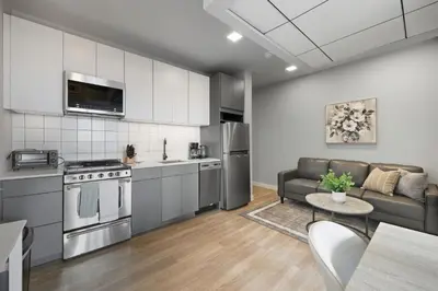 a kitchen and living room with a couch and a table at Bright urban studio, fully furnished in Philadelphia
