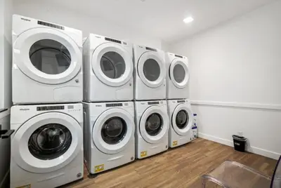 four washers and dryers are lined up in a room at Bright urban studio, fully furnished in Philadelphia