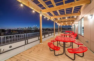 a row of red tables and chairs on a balcony at Bright urban studio, fully furnished in Philadelphia