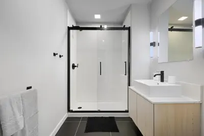 a white bathroom with a shower and a sink at Bright urban studio, fully furnished in Philadelphia