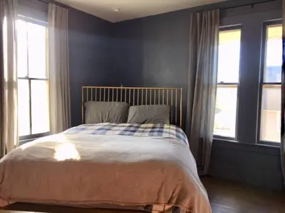 a bed in a bedroom with two windows at Zen in Narrowsburg Retreat near Town in Narrowsburg