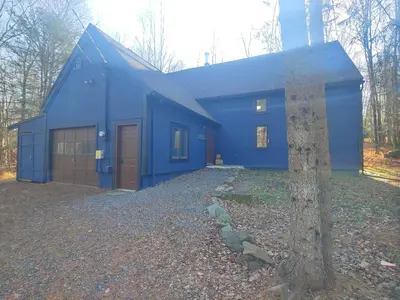 a blue house with a tree in front of it at Ambro's Place in Lake Ariel