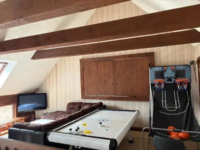 a living room with a couch and a ping pong table at Ambro's Place in Lake Ariel