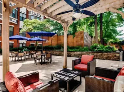 an outdoor patio with chairs and tables and umbrellas at Carriage House Sleek 1BR Apartment in Philadelphia