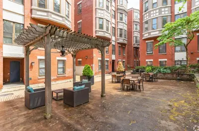 a courtyard with tables and chairs and a wooden pergola at Carriage House Sleek 1BR Apartment in Philadelphia