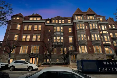 a large brick building with cars parked in front of it at Carriage House Sleek 1BR Apartment in Philadelphia