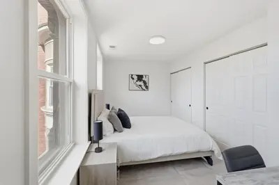 a white bedroom with a bed and a window at Carriage House Stylish 1BR Retreat in Philadelphia
