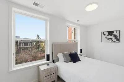 a white bedroom with a bed and a window at Carriage House Stylish 1BR Retreat in Philadelphia