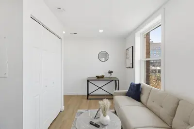 a white living room with a couch and a window at Carriage House Stylish 1BR Retreat in Philadelphia