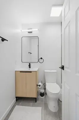 a bathroom with a toilet and a mirror at Carriage House Stylish 1BR Retreat in Philadelphia