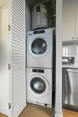 a washer and dryer in a kitchen with a washing machine at Cozy, Modern Living at Carriage House in Philadelphia
