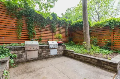 a backyard with a fence and two stove tops at Cozy, Modern Living at Carriage House in Philadelphia