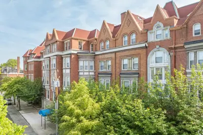 a large brick building with trees in front of it at Cozy, Modern Living at Carriage House in Philadelphia