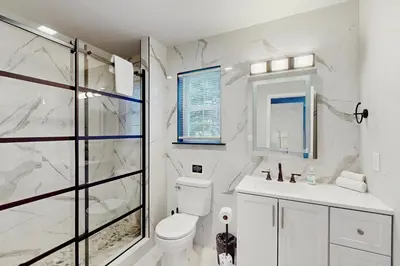 a white bathroom with a toilet and a shower at The Nest in Long Pond