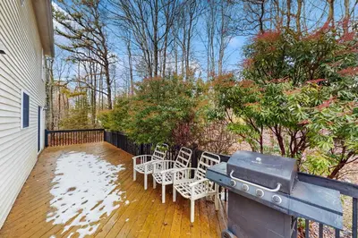 a deck with chairs and a grill on a house at The Nest in Long Pond