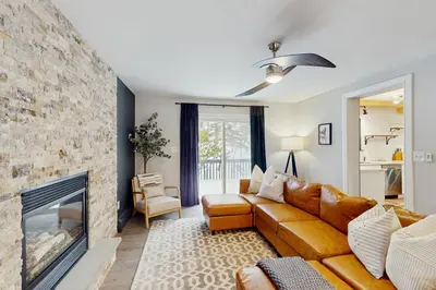 a living room with a couch and a fireplace at The Nest in Long Pond