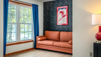 a living room with a couch and a window at Epic Poconos Pad - Pool - Hot Tub - Gym - Golf Sim in East Stroudsburg