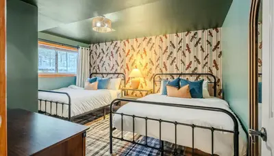 a room with two beds and a table in it at Epic Poconos Pad - Pool - Hot Tub - Gym - Golf Sim in East Stroudsburg