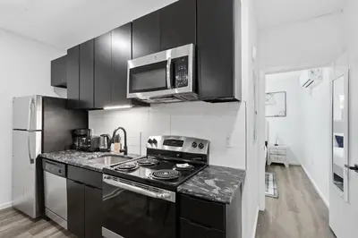 a black and white kitchen with a stove and a microwave at Fully equipped apartment in great location in Philadelphia
