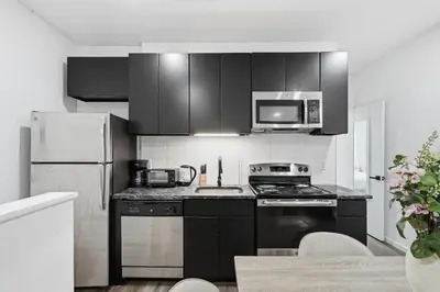 a kitchen with black cabinets and stainless steel appliances at Fully equipped apartment in great location in Philadelphia
