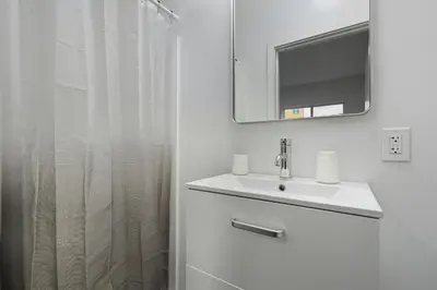 a white bathroom with a sink and a mirror at Fully equipped apartment in great location in Philadelphia