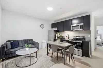 a kitchen and living room with a couch and a table at Sleek apartment with modern amenities in Philadelphia