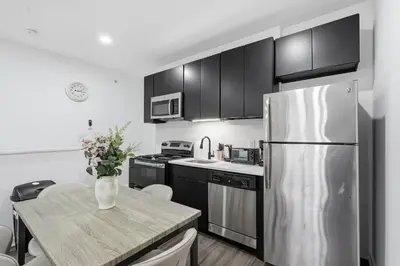 a kitchen with a stainless steel refrigerator and a table at Sleek city apartment with modern finishes in Philadelphia