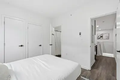 a bedroom with white walls and a white bed at Sleek city apartment with modern finishes in Philadelphia