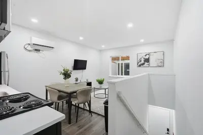 a white kitchen with a table and a dining room at Sleek city apartment with modern finishes in Philadelphia