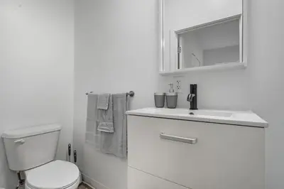 a white bathroom with a toilet and a sink at Contemporary apartment with amenities in Philadelphia