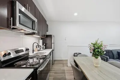 a kitchen with a stove and a table with a vase of flowers at Contemporary apartment with amenities in Philadelphia