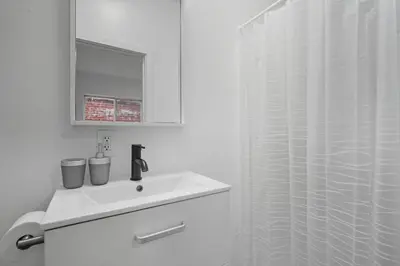 a white bathroom with a sink and a shower at Contemporary apartment with amenities in Philadelphia