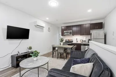 a living room with a couch and a kitchen at Contemporary apartment with amenities in Philadelphia
