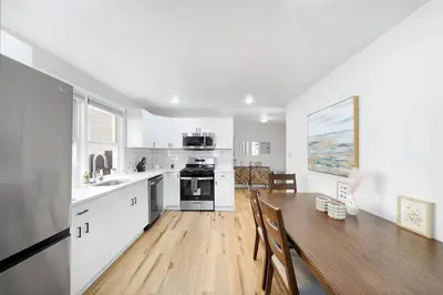 a kitchen with a wooden table and a dining room at Family Villa Close to NYC Attractions and Airport in Bayonne