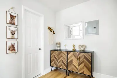a white room with a black dresser and a door at Family Villa Close to NYC Attractions and Airport in Bayonne
