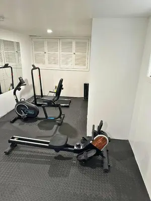 a gym with three exercise bikes in a room at Family Villa Close to NYC Attractions and Airport in Bayonne