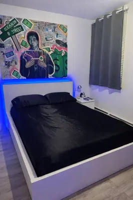 a bedroom with a bed with a painting on the wall at Minimalist Midtown West Studio in Central Manhattan in New York