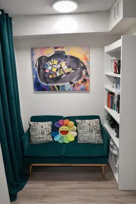 a green couch in a living room with a painting at Minimalist Midtown West Studio in Central Manhattan in New York