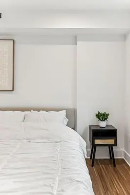 a bedroom with a white bed and a table with a plant at Modern 3BR Walk to Museums in Philadelphia